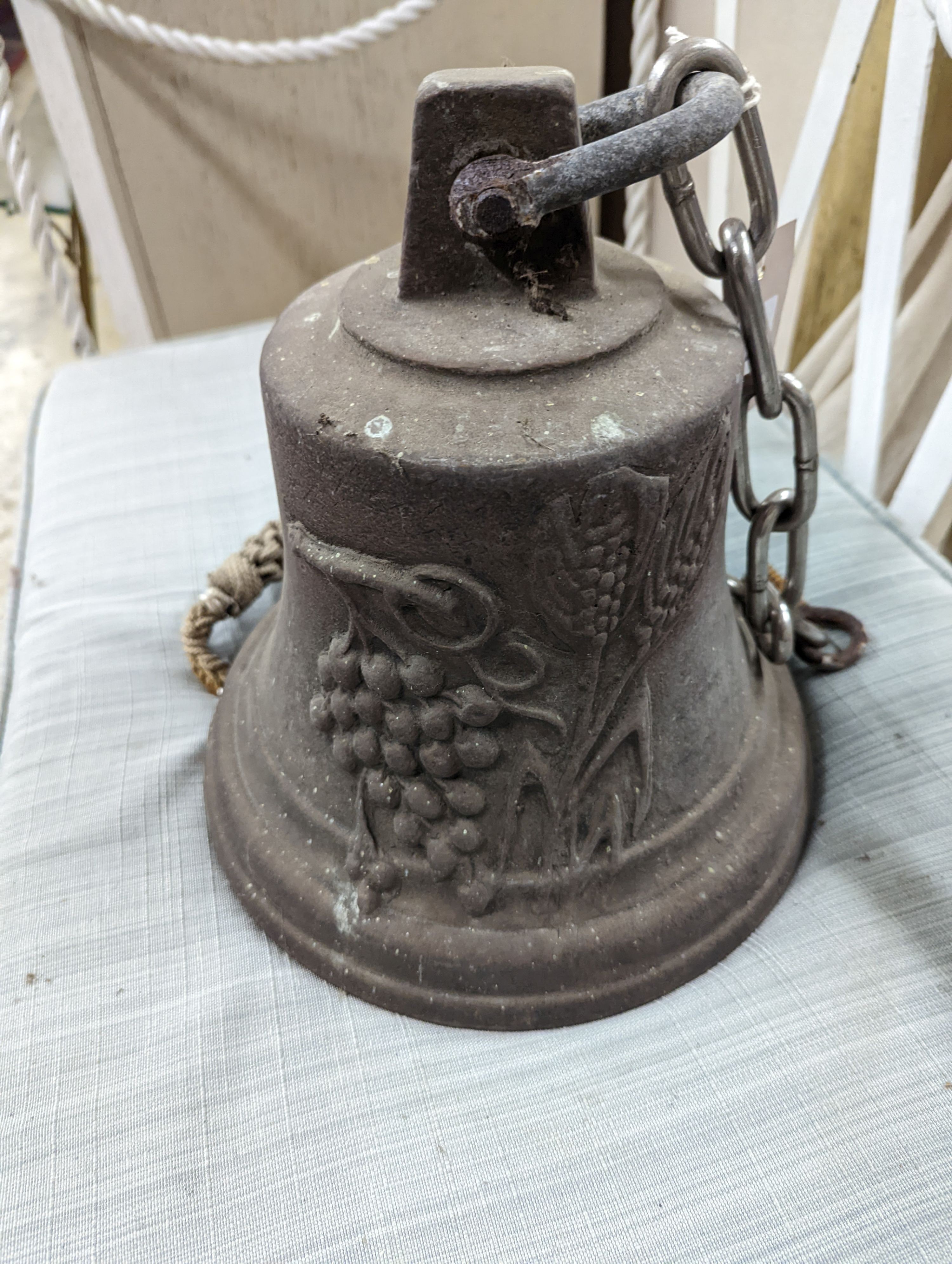 A cast metal bell moulded with deer and fruit, height 24cm